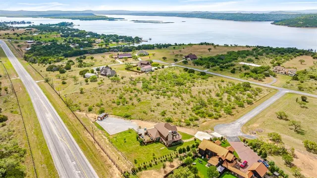 an aerial view of residential houses with outdoor space and trees