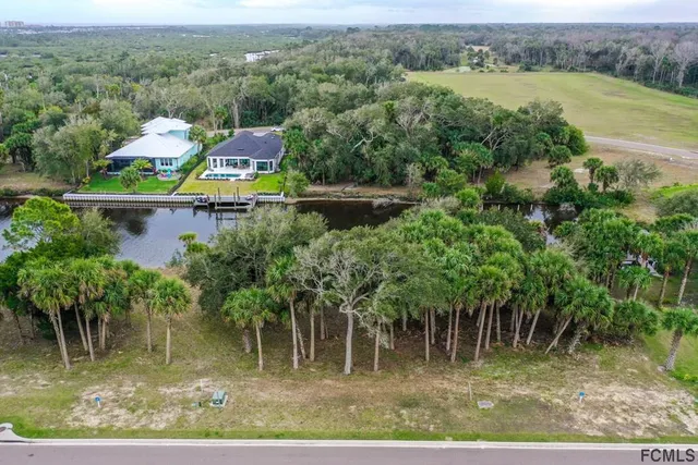 an aerial view of a house with a yard and lake view