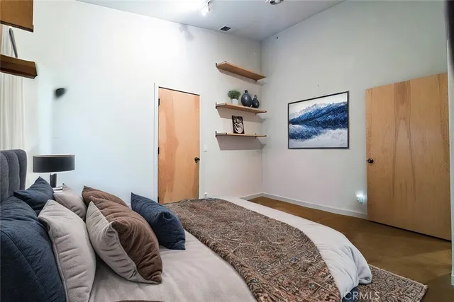 a bedroom with a bed and a painting on the wall