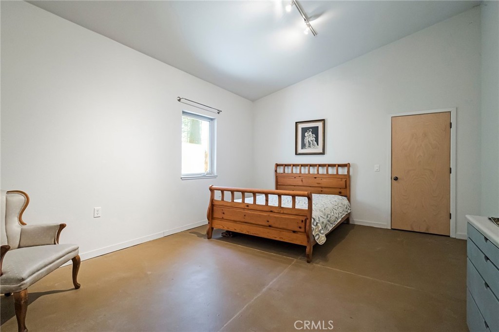 4911 Contentment Lane Forest Ranch, CA 95942 - Photo 21 of 30 a bed sitting in a bedroom next to a window with a chair