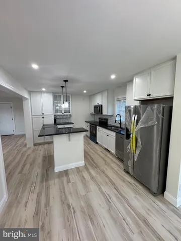 a kitchen with stainless steel appliances kitchen island granite countertop a refrigerator and a stove top oven