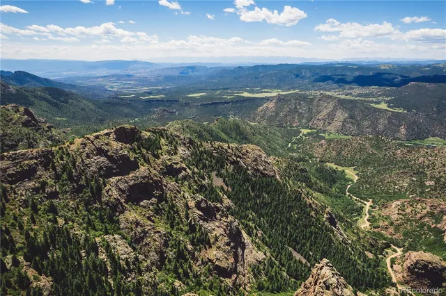 a view of a mountain range with lush green forest