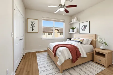 a bedroom with a bed and wooden floor