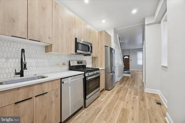 a kitchen with kitchen island a sink stainless steel appliances and cabinets