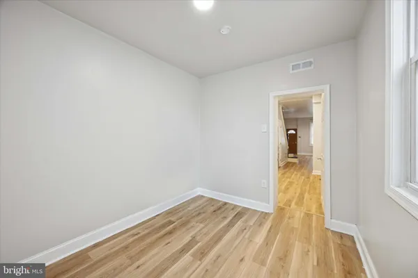 a view of a room with wooden floor and a bathroom