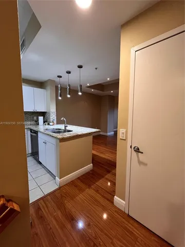 a kitchen with stainless steel appliances a refrigerator and a wooden floor