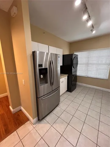 a kitchen with granite countertop a refrigerator and a sink