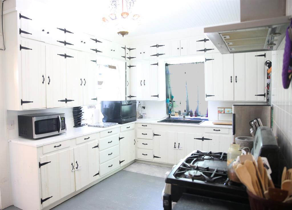 1500 Bonham Street Commerce, TX 75428 - Photo 16 of 29 a kitchen with kitchen island white cabinets and white appliances