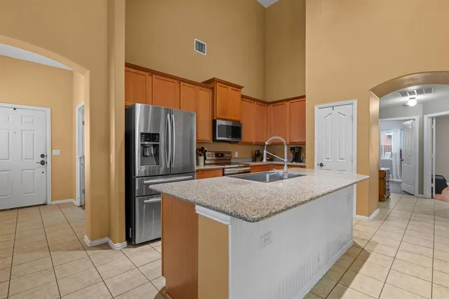 a kitchen with kitchen island granite countertop a sink counter and chairs