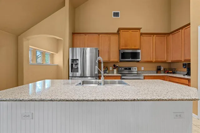a kitchen with stainless steel appliances granite countertop a sink stove and refrigerator