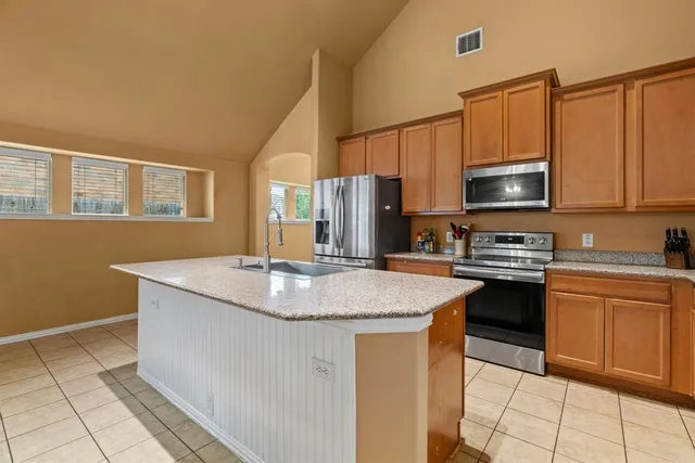 a kitchen with granite countertop a sink and a stove top oven