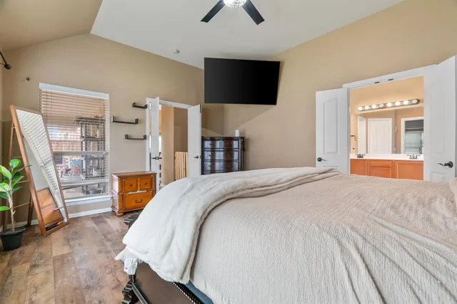 a bedroom with a bed and a flat tv screen on a dresser