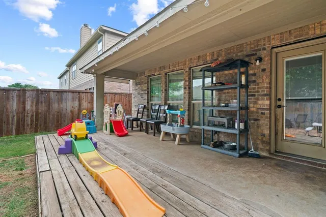 a view of a patio with a table and chairs and a barbeque