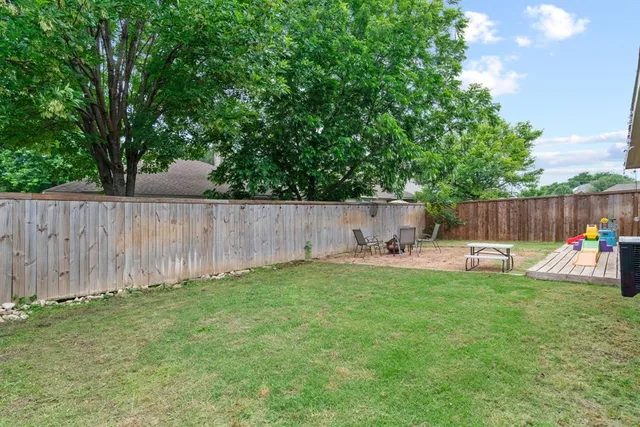 a view of a backyard with a garden and wooden fence