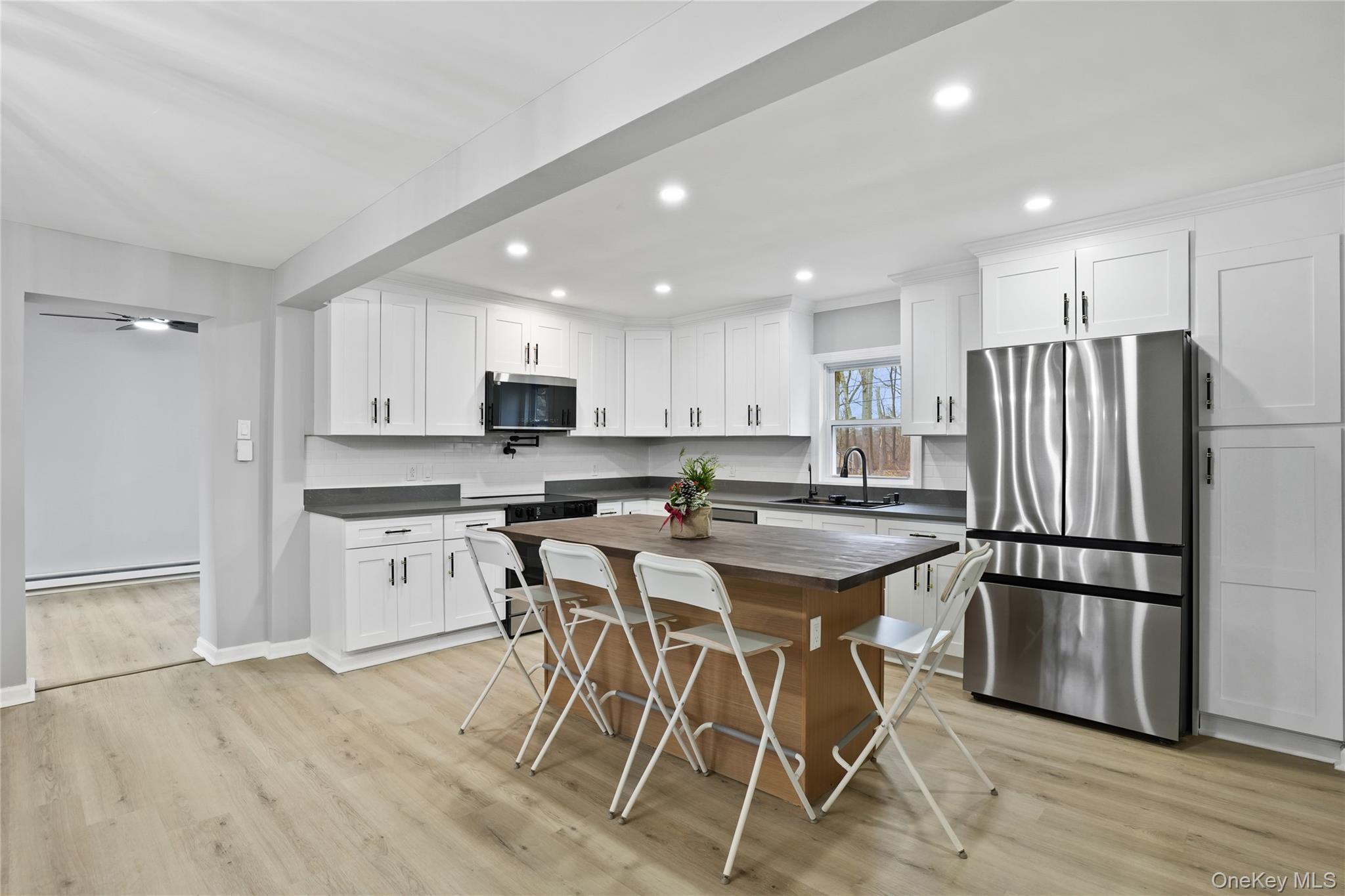 517 East Mountain Road North, Unit 515517 Cold Spring, NY 10516 - Photo 3 of 30 a kitchen with stainless steel appliances granite countertop a refrigerator a sink dishwasher a stove and white cabinets with wooden floor