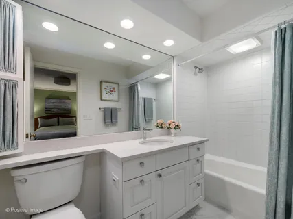 a bathroom with a sink double vanity granite tub shower and a mirror