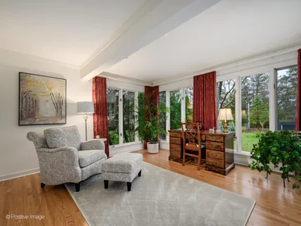a living room with furniture and a large window with wooden floor