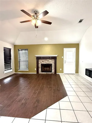 a view of an empty room with a fireplace and a window