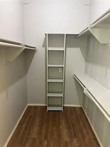 a view of walk in closet with empty racks