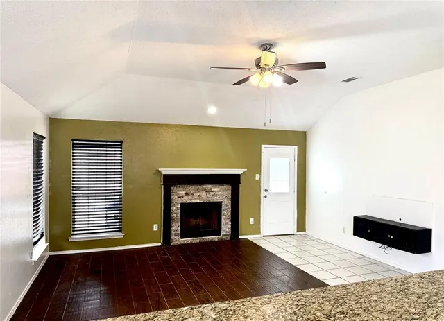 a view of an empty room with a fireplace and a window