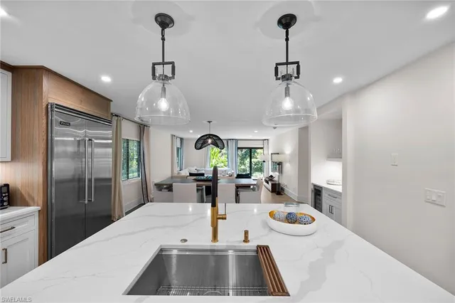 a kitchen with sink refrigerator and large window