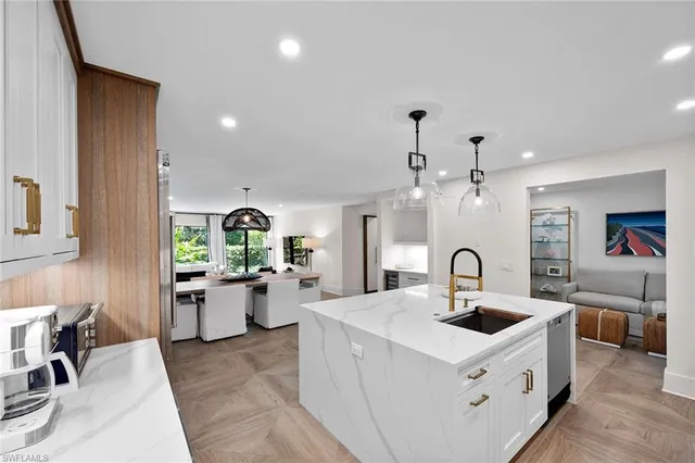 a kitchen that has a lot of cabinets a sink and appliances in it