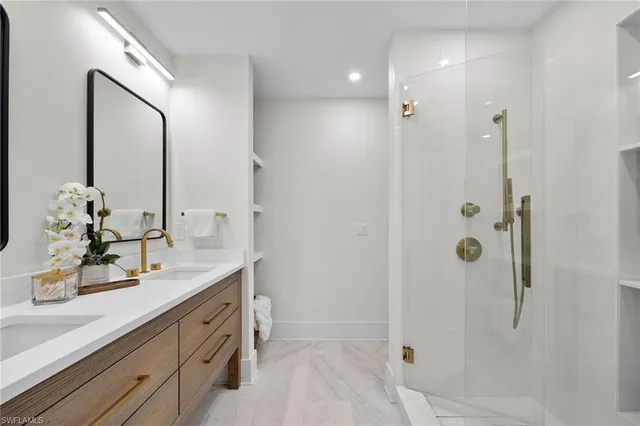 a bathroom with a double vanity sink mirror and shower