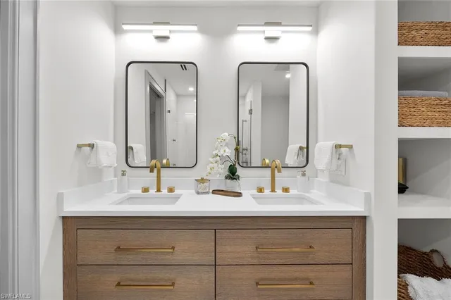 a bathroom with double vanity sinks and a mirror