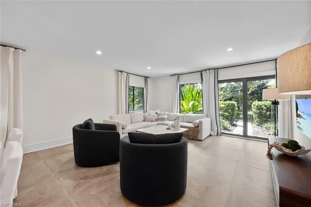 a living room with furniture and large windows