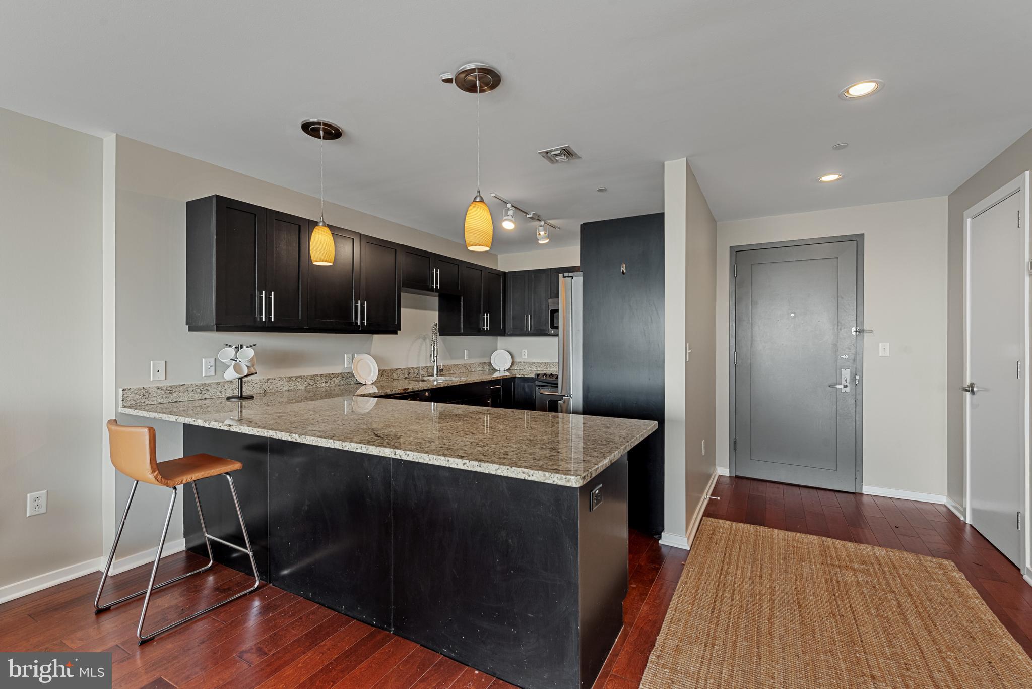 1200 Steuart Street, Unit 416 Baltimore, MD 21230 - Photo 16 of 37 a kitchen with a sink cabinets and wooden floor