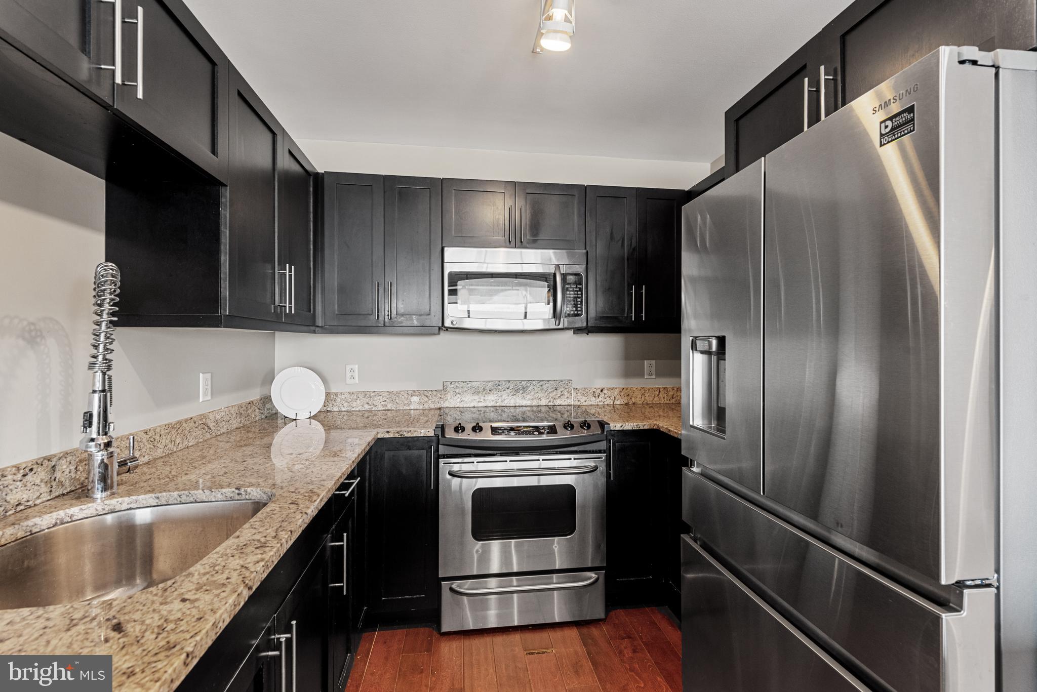 1200 Steuart Street, Unit 416 Baltimore, MD 21230 - Photo 18 of 37 a kitchen with granite countertop a refrigerator stove and sink