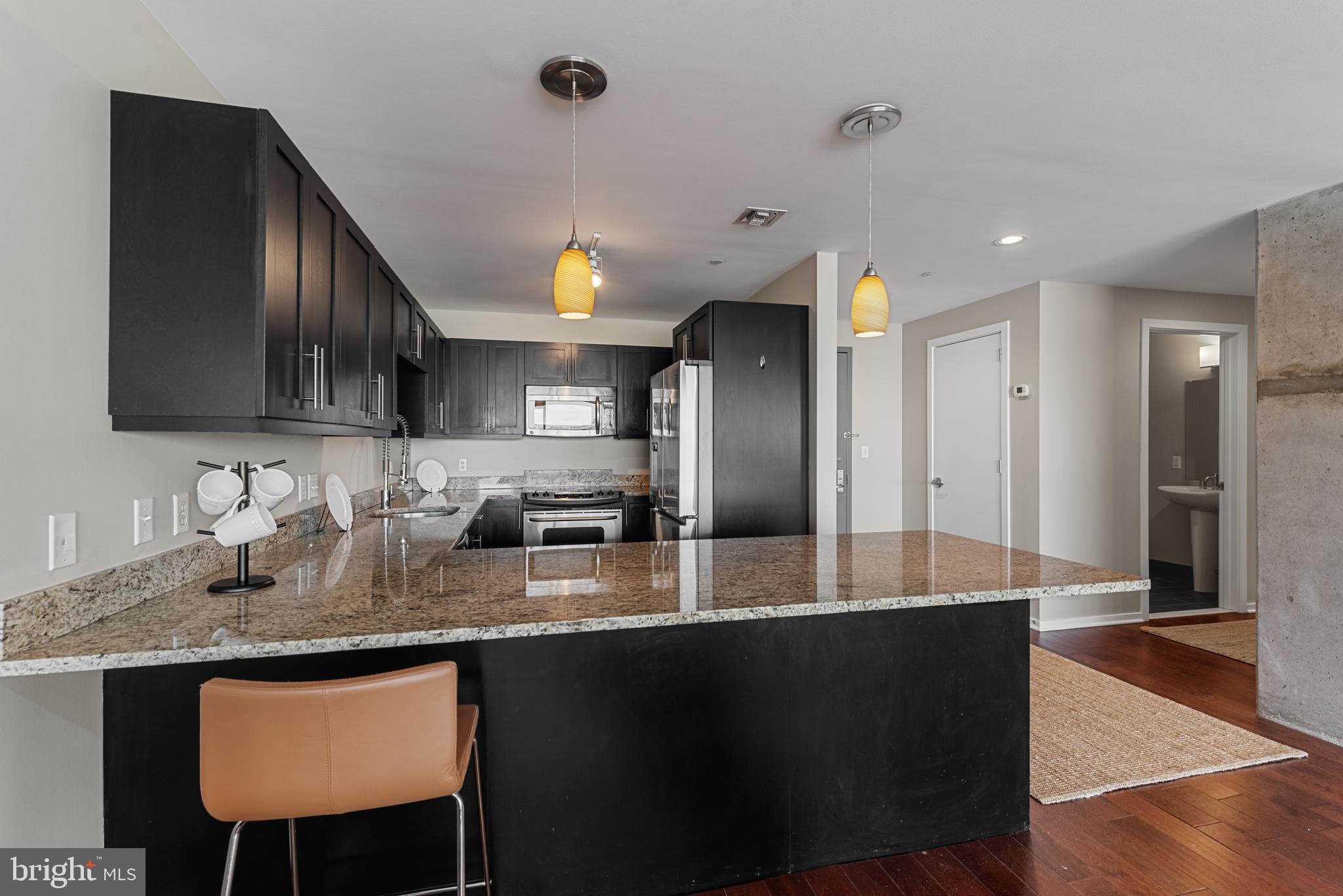 1200 Steuart Street, Unit 416 Baltimore, MD 21230 - Photo 20 of 37 a kitchen with stainless steel appliances granite countertop a sink a stove and a refrigerator