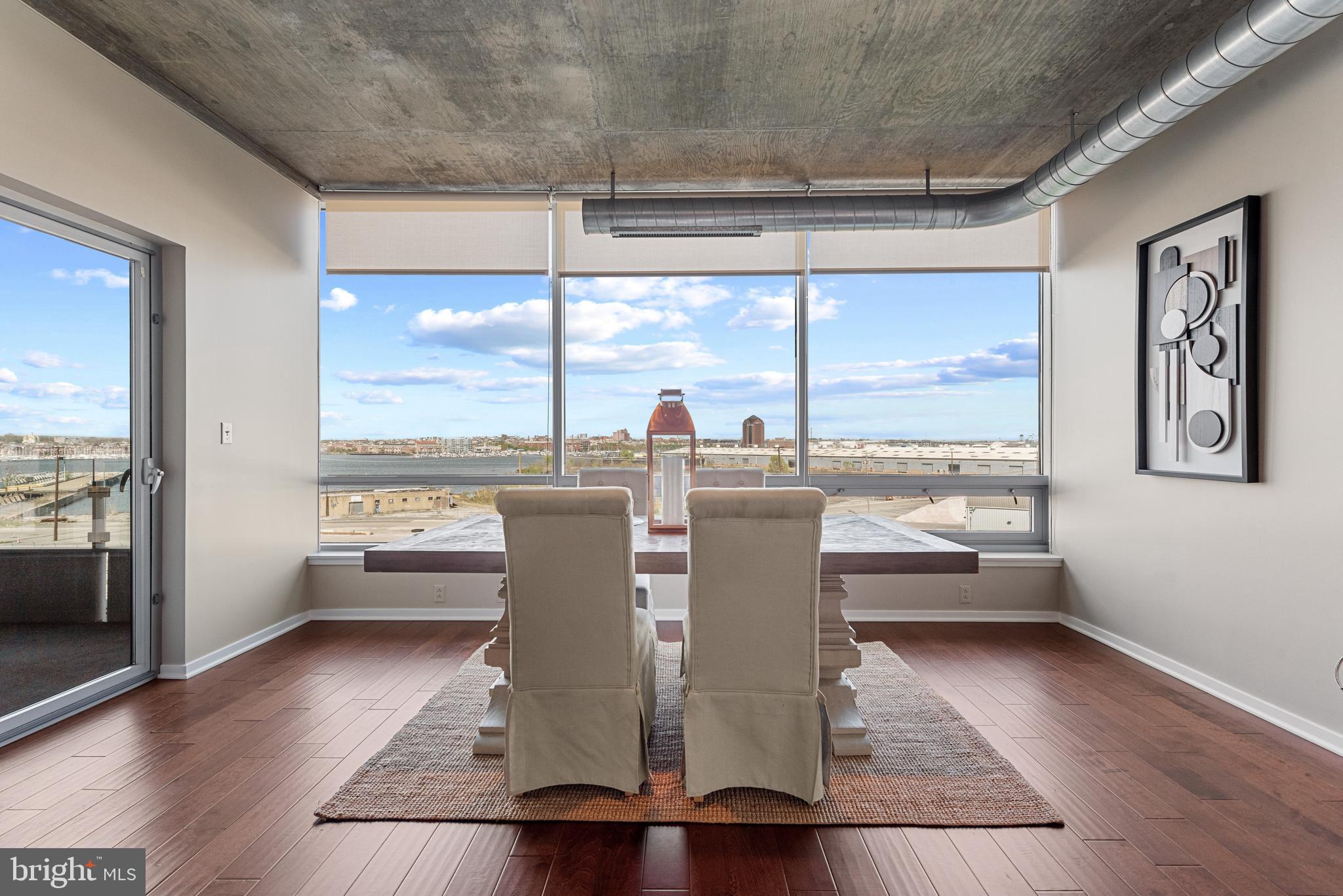 1200 Steuart Street, Unit 416 Baltimore, MD 21230 - Photo 2 of 37 a view of a dining room with furniture window and wooden floor