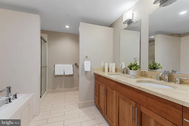 a spacious bathroom with a double vanity sink a mirror and a toilet