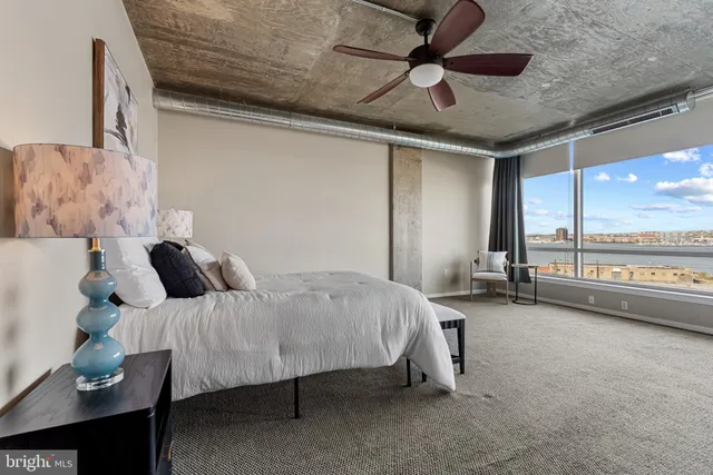 a spacious bedroom with a bed and a chandelier