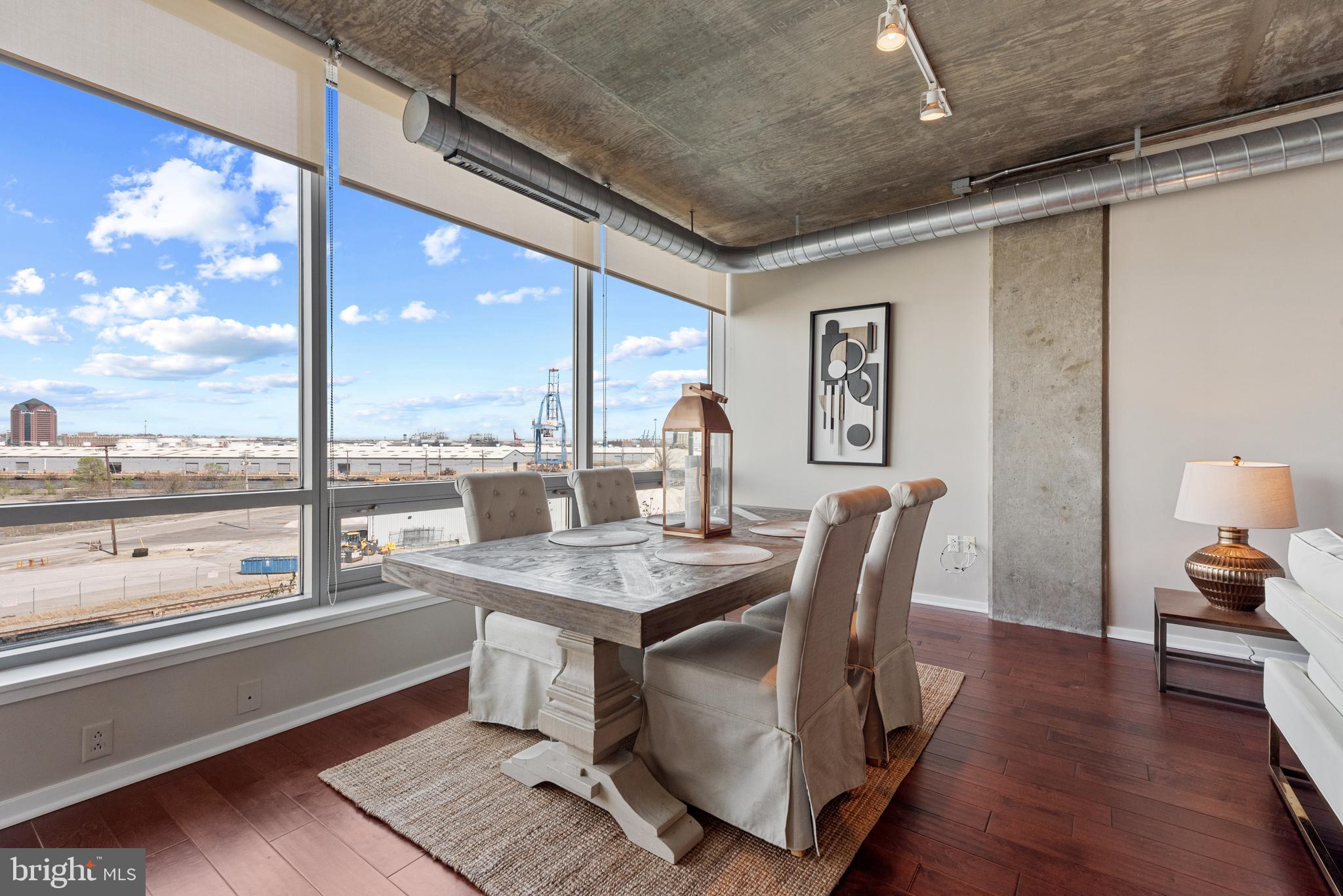 1200 Steuart Street, Unit 416 Baltimore, MD 21230 - Photo 3 of 37 a dining room with furniture a window and wooden floor