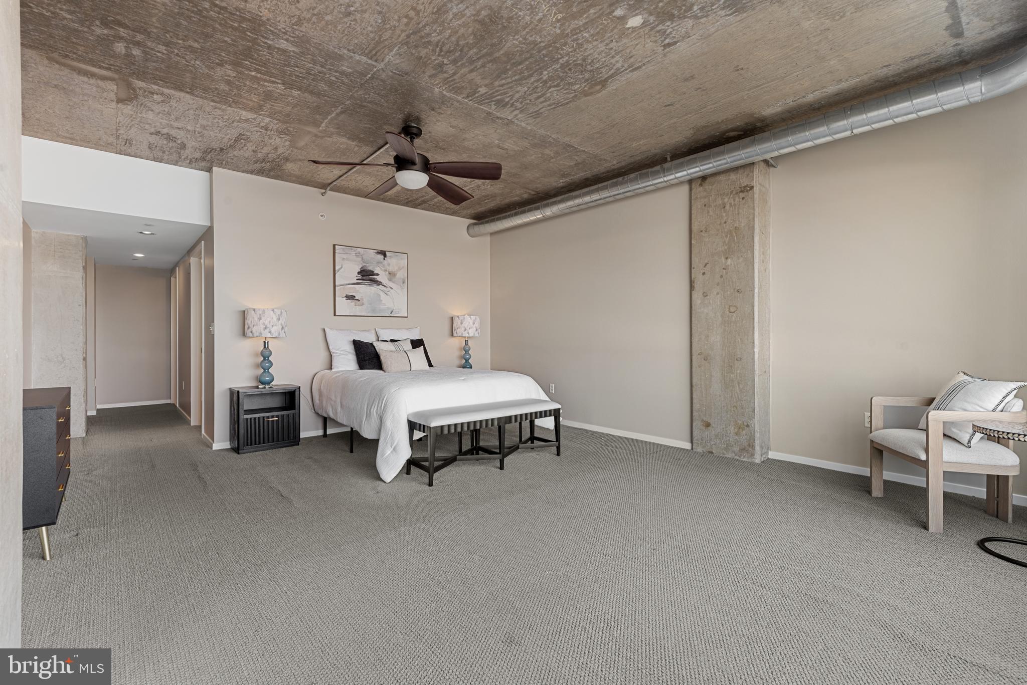 1200 Steuart Street, Unit 416 Baltimore, MD 21230 - Photo 31 of 37 a spacious bedroom with a bed and a chandelier