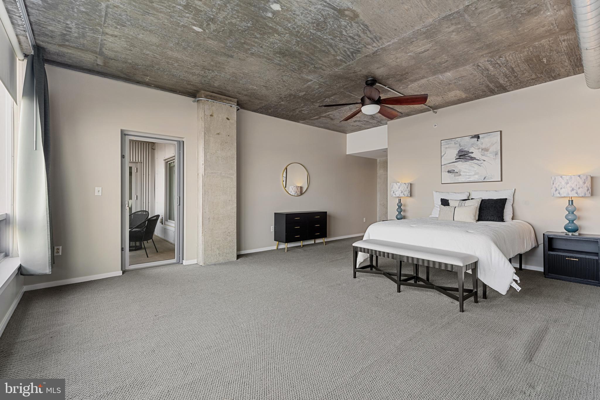 1200 Steuart Street, Unit 416 Baltimore, MD 21230 - Photo 32 of 37 a spacious bedroom with a bed and a ceiling fan