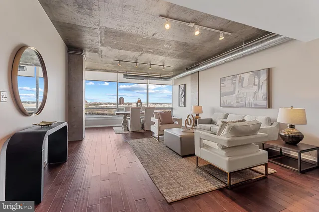 a living room with furniture a table and a large window