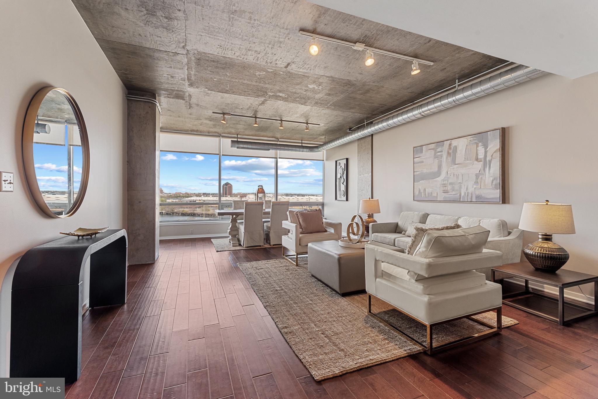 1200 Steuart Street, Unit 416 Baltimore, MD 21230 - Photo 6 of 37 a living room with furniture a table and a large window