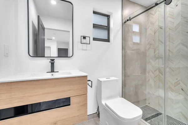 a bathroom with a shower sink and mirror