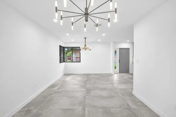 an empty room with a ceiling fan and a rug