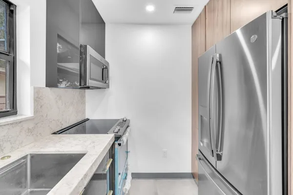 a kitchen with stainless steel appliances granite countertop a refrigerator and a sink