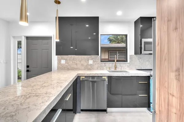 a view of a kitchen with a sink and mirror