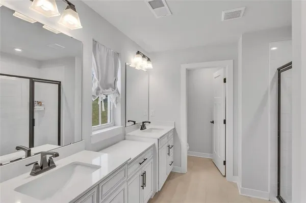 a bathroom with double vanity sinks and a mirror