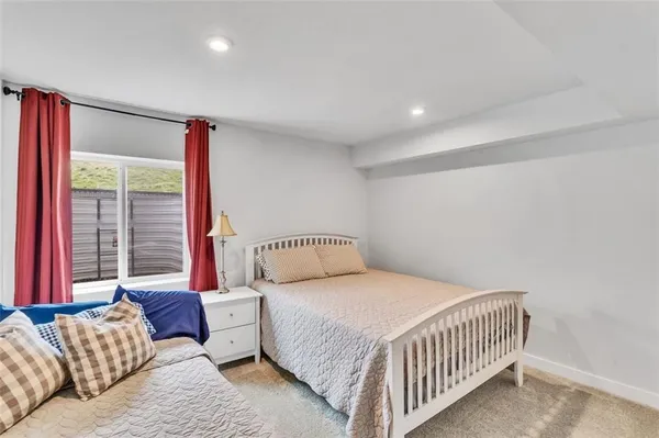 a bedroom with a bed and a large window with wooden floor