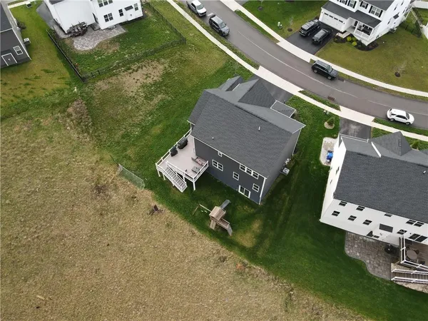 an aerial view of a house with a yard basket ball court and parked cars