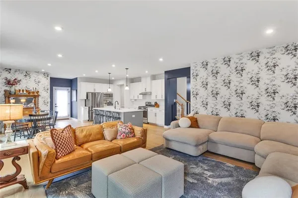 a living room with furniture and a view of kitchen