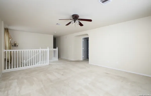 a view of a room with a ceiling fan and entryway