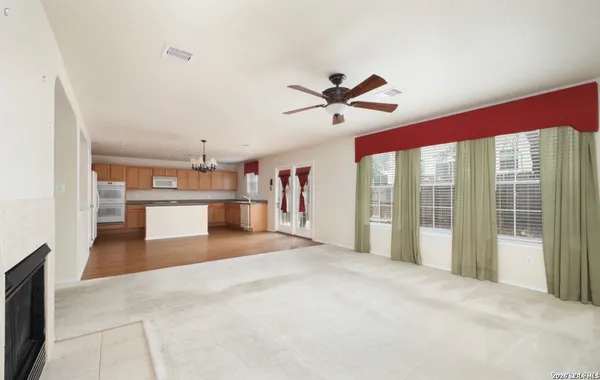 a kitchen with stainless steel appliances granite countertop a refrigerator a sink dishwasher a oven and white cabinets with wooden floor